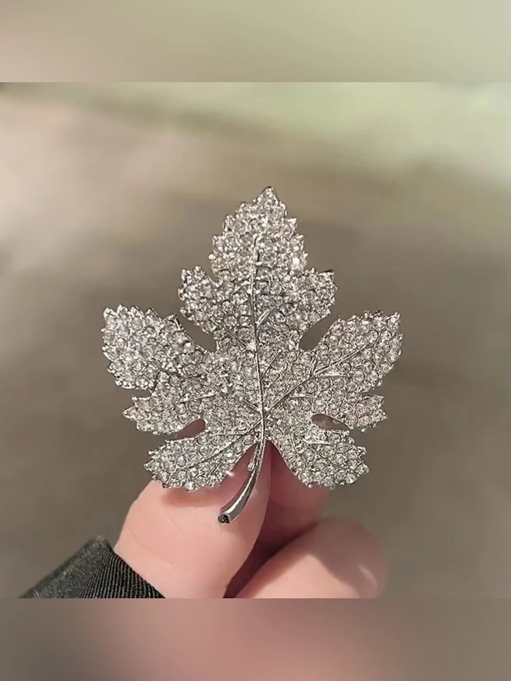 Sparkling silver-tone maple leaf brooches featuring pavé-set clear rhinestones.
